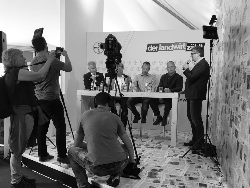 Bei einer Pressekonferenz wird eine Expertenrunde mit vier Personen vor laufender Kamera interviewt.