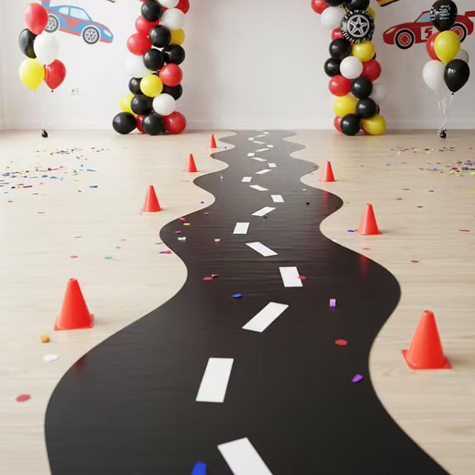 A winding road decor with white dashes on a floor, flanked by red cones, colorful balloons, and car-themed wall art, festive mood.