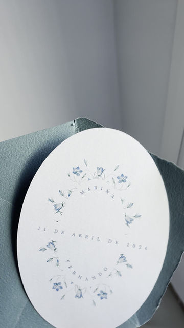Vídeo detalle de invitación de boda índigo con forma ovalada y sobre artesanal aguamarina