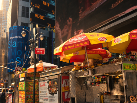 Halal food cart on a New York City street beneath skyscrapers