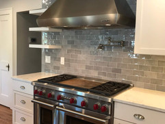 front view of double oven kitchen remodel with stainless steel range hood