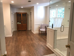 bathroom renovation project with wood floors and glass shower and custom storage
