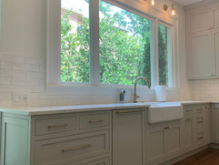 kitchen remodel with grey cabinetry and large window over sink