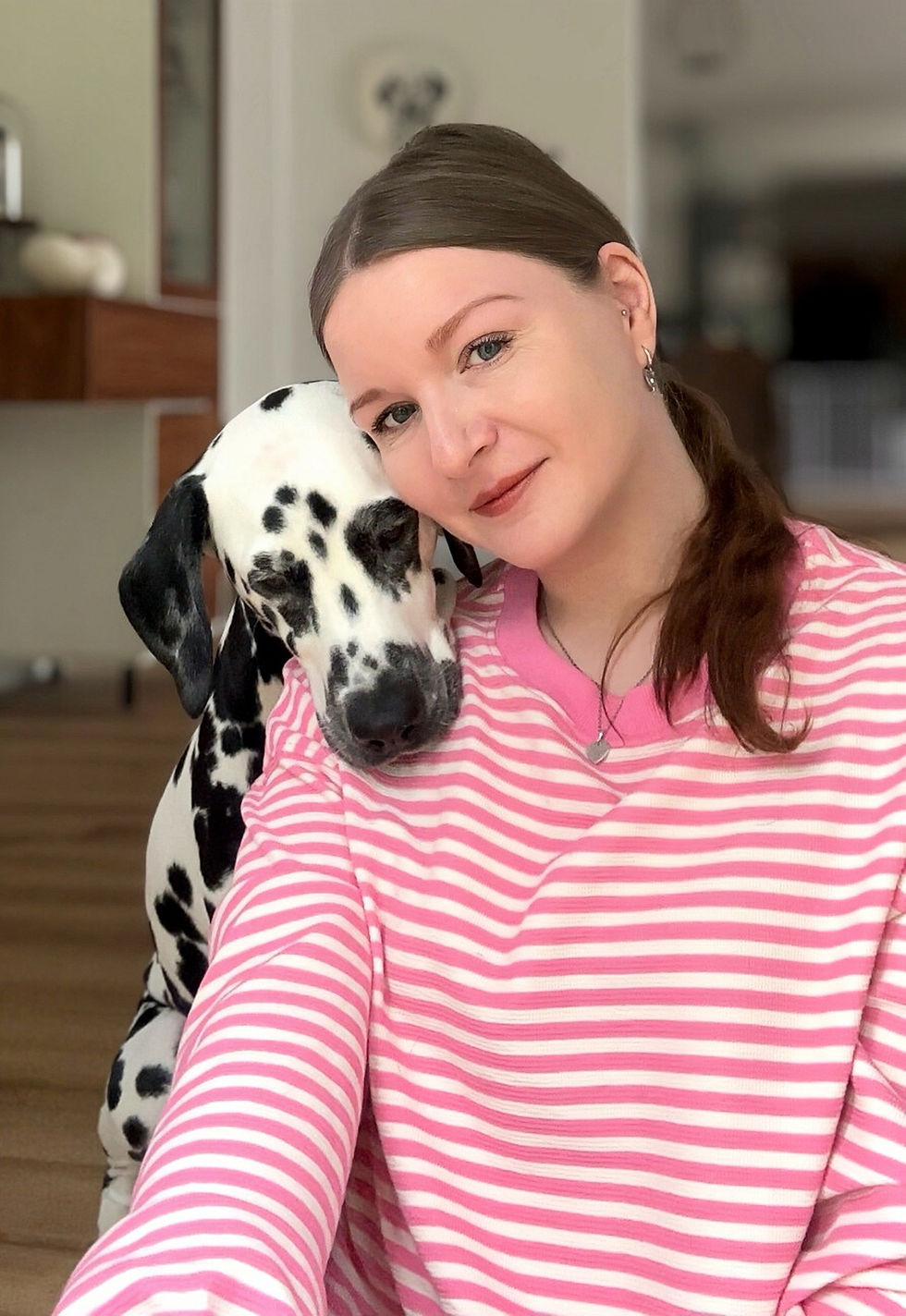 Lächelnde Frau mit Dalmatiner auf der Schulter