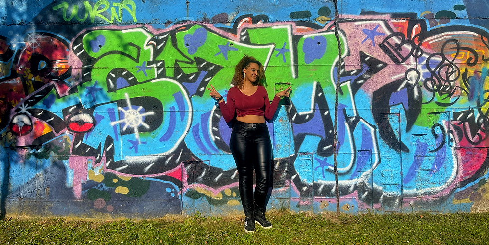 Luckychi posiert vor einer Grafittiwand