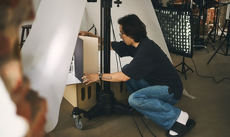 攝影棚工作紀錄：利用多層白色反光板與黑色遮光卡，微調保養品罐身的明暗交界線，展現李室工坊對保養品包裝質感的極致追求。