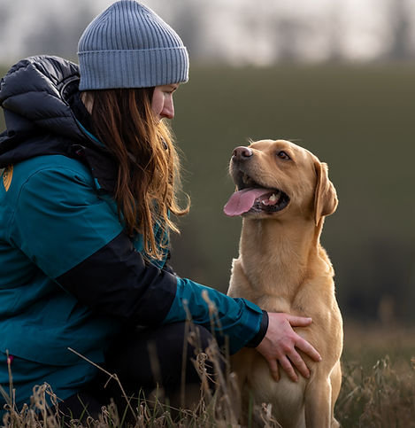 Lara the dog trainer crouched with her golden Labrador, Seamus