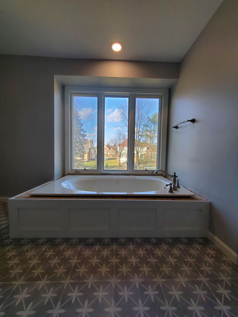 Bay window in bathroom behind jacuzzi tub
