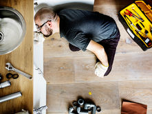a plumber looking underneath a sink