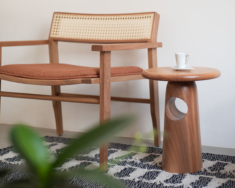 Living room corner with the Singular Side Table next to a wooden bench with caned back