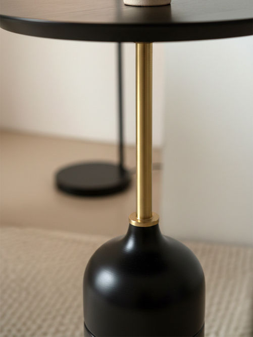 Mesa lateral Huelva com abajur integrado, close-up da base preta arredondada com detalhe em metal dourado e haste metálica