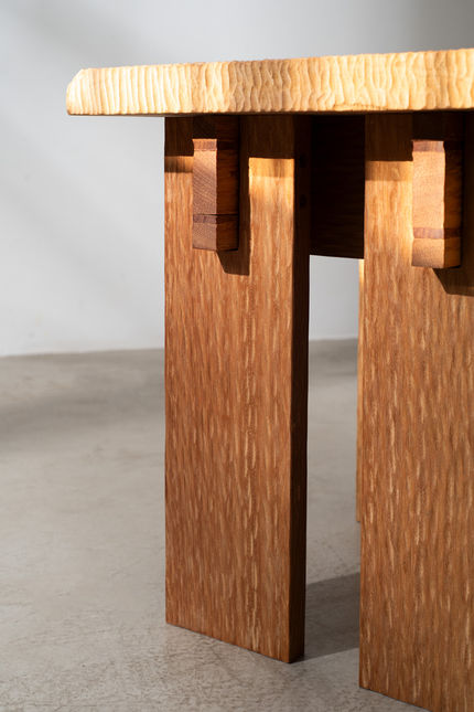 Underside detail of the Guama Stool, showing the slab legs and the through-tenons that lock the seat