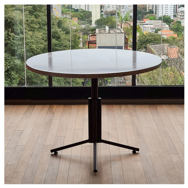 Prosa Table with light terrazzo top in front of a full-height window overlooking the city