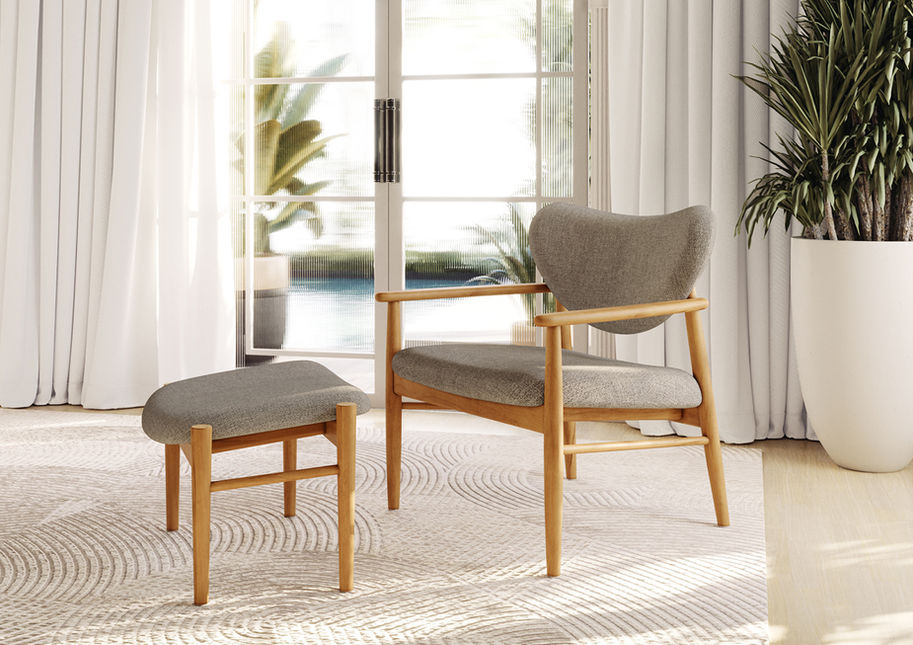 Pietro Lounge Chair and matching footrest in grey upholstery on a rug beside a garden door