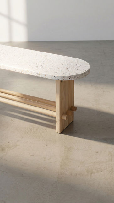 Sunlight across the terrazzo seat and pale wood leg of the Trini Bench