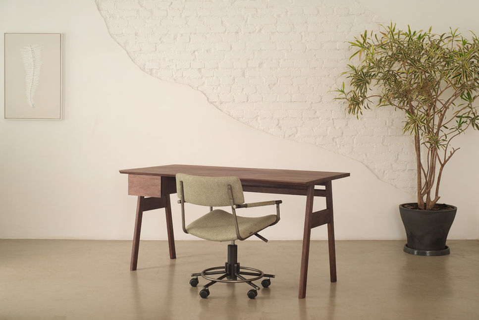 Home office with the Nonno Desk, a sage office chair and a potted tree beside a brick wall
