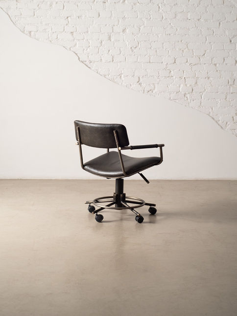 Rear three-quarter view of the dark upholstered Luiza Office Chair showing the height adjustment lever and five-caster base