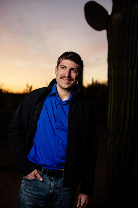 Portrait of a man in the desert durong sunset in front of a saguaro at Broadway Trailhead Tucson.