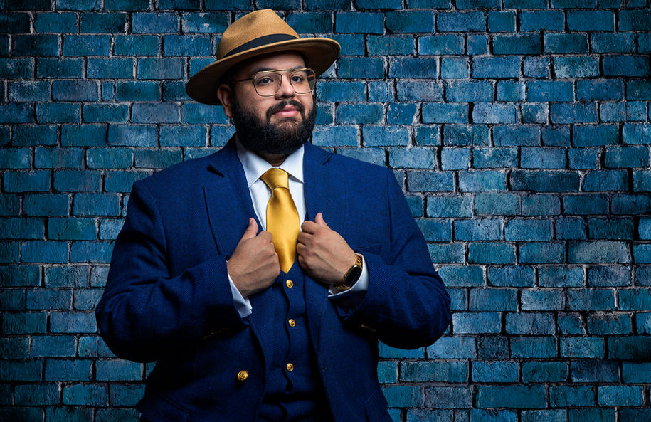 Tucson Portrait of a man in a blue suit in front of a blue brick wall