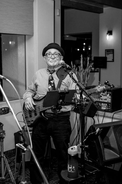 Black & White photo of a gentleman playing a guitar.