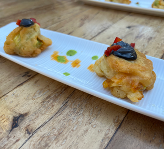 Coated Zuchini flower stuffed with shrimp covered in homemade black mayonaise.HEIC