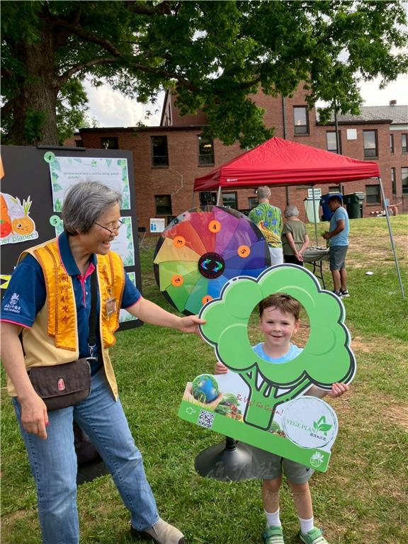BLIA North Carolina Chapter President May Shiue encourages children to participate in the vegetarian photo check-in activity.