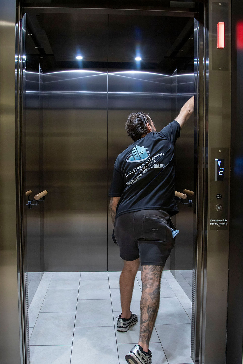 Man cleaning inside elevator