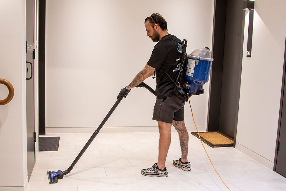 Man vacuuming inside building corridor