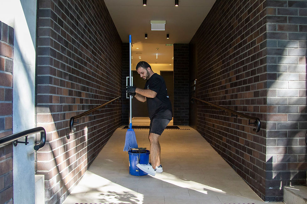 Man moping entrance of building