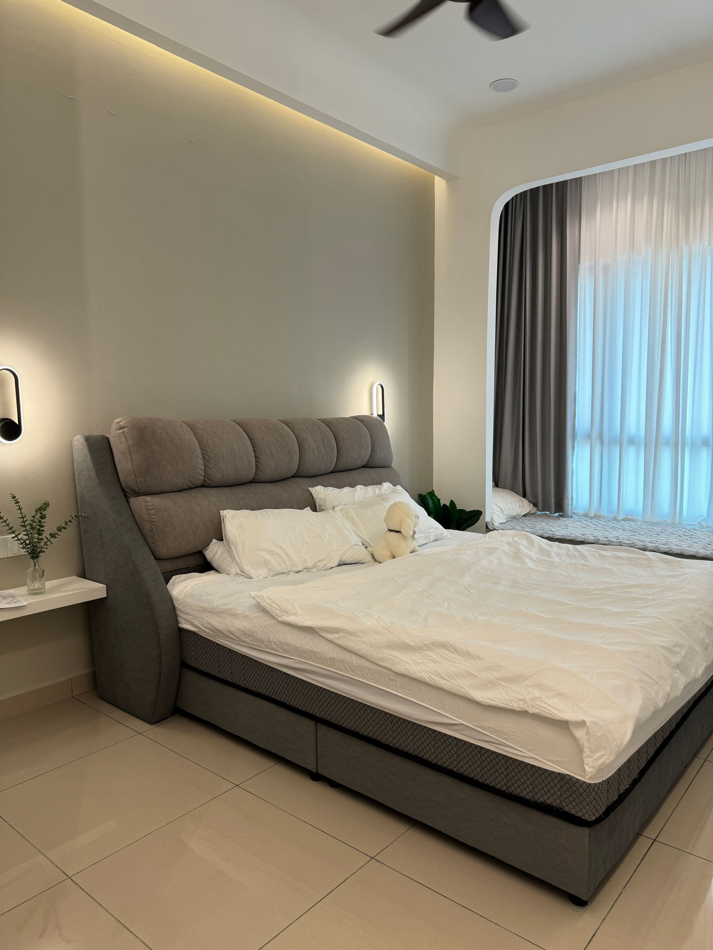 Modern bedroom with a large bed and soft lighting.