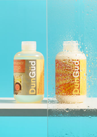 Dungüdshampoo bottles showing liquid and spray, PRODUCT PHOTOGRAPHY in a blue background. product photography by Karolina Ferbei Photography