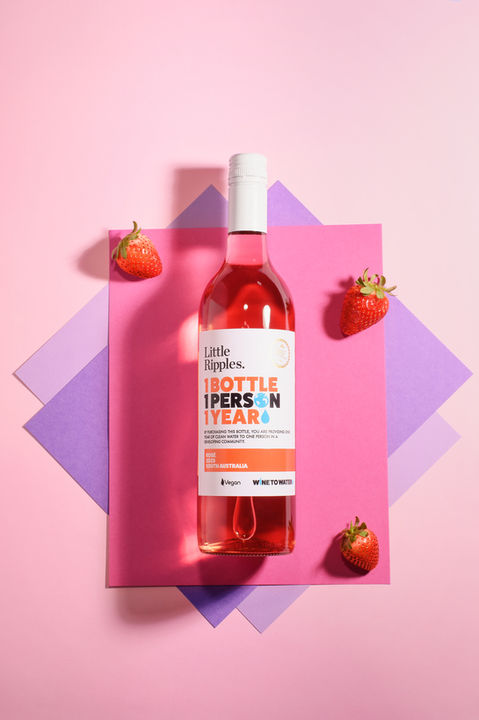 Bottle wine with strawberries on coloured background, product photography by Karolina Ferbei Photography