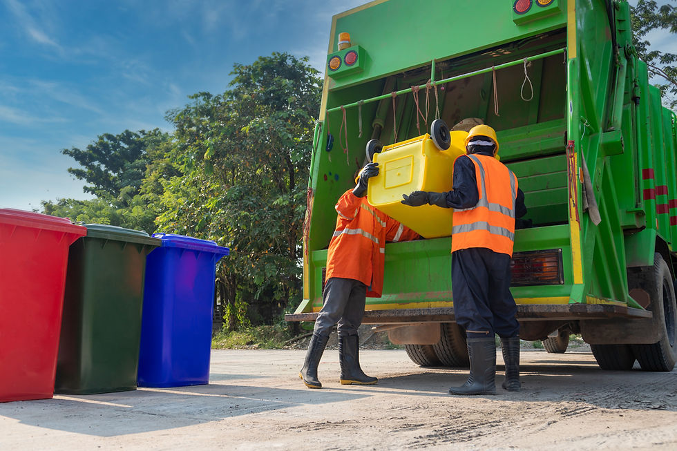 Teamwork garbage men working together on emptying dustbins for trash removal with truck lo