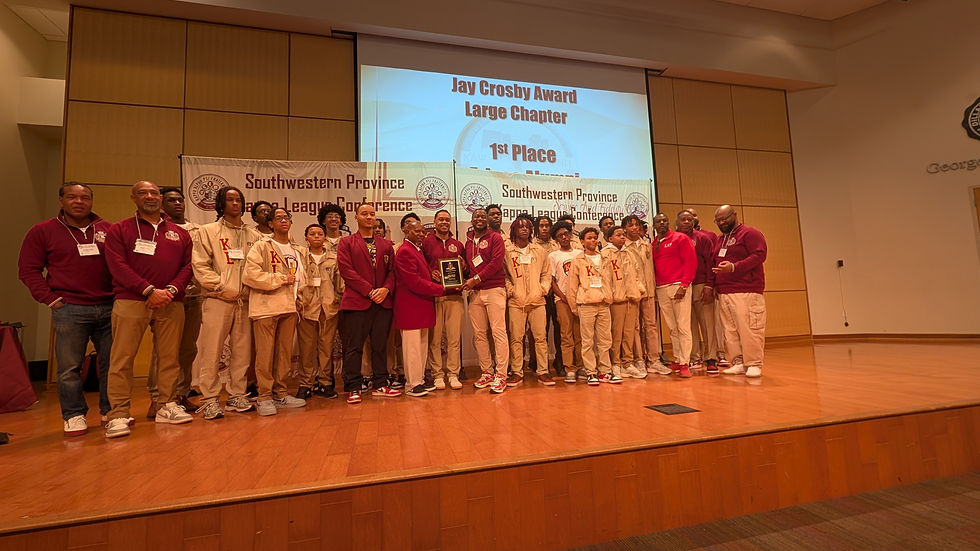 Kappa League members and mentors stand together on a stage during an awards ceremony as a group receives the Jay Crosby Award for Large Chapter, with a screen behind them displaying “1st Place.