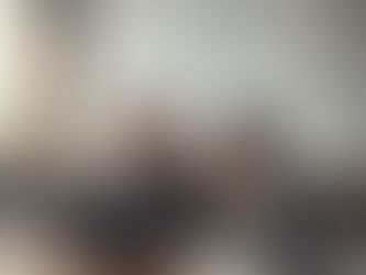 A male professor is frustrated with an AI interface on his laptop, while a female colleague smiles curiously in a university classroom with "AI TOOLS" written on the whiteboard.