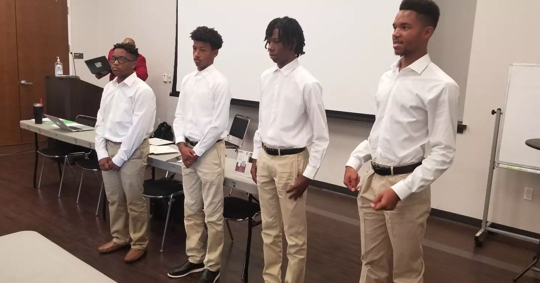 Group of four young men speaking