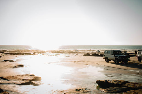 sun shining bright on the beach with a big suv