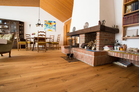 Wohnraum mit Holzboden und Cheminée im Innenausbau