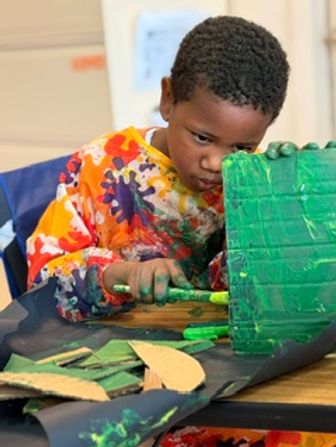 A student painting at his desk.