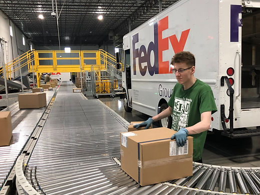 A participant in St. Coletta's Supported Employment Program prepares boxes for a Fed Ex delivery.
