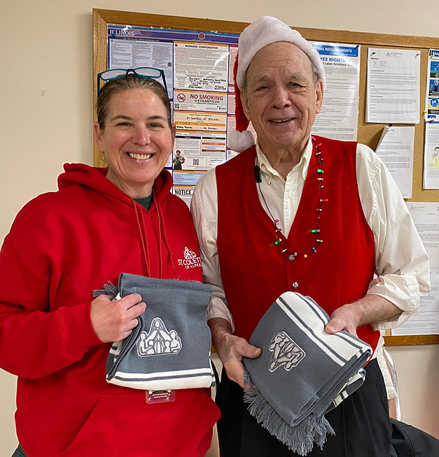 CEO Heather Benedick and SPA President Jack Angelus hold up knit scarves with St. Coletta'