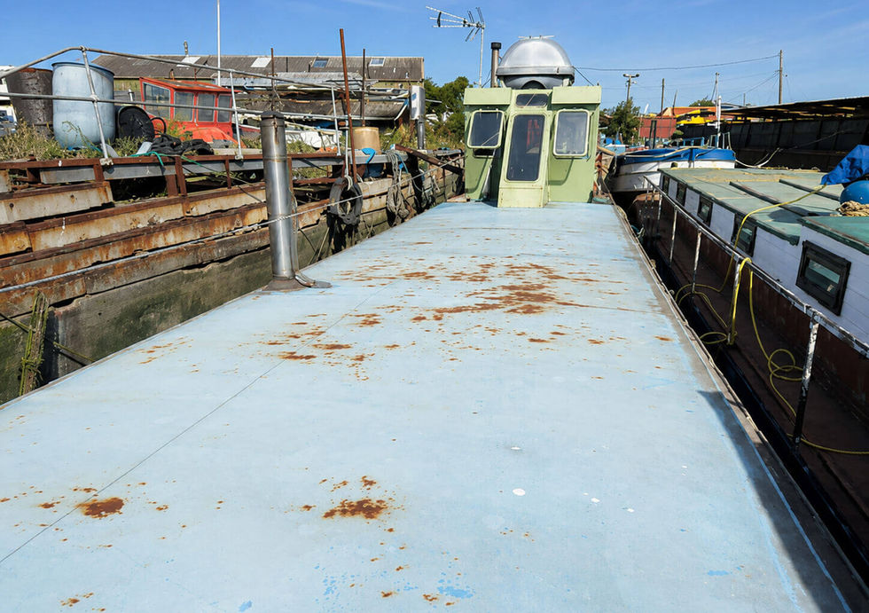 Large flat roof deck on project houseboat with wheelhouse and surrounding marina views.