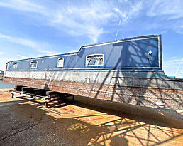 Kirby Moor canal boat, a narrowboat, dry-docked for maintenance on a sunny day.