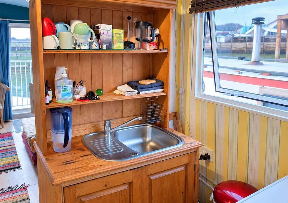 Fitted kitchen sink and storage area aboard Peggy Rose residential houseboat.
