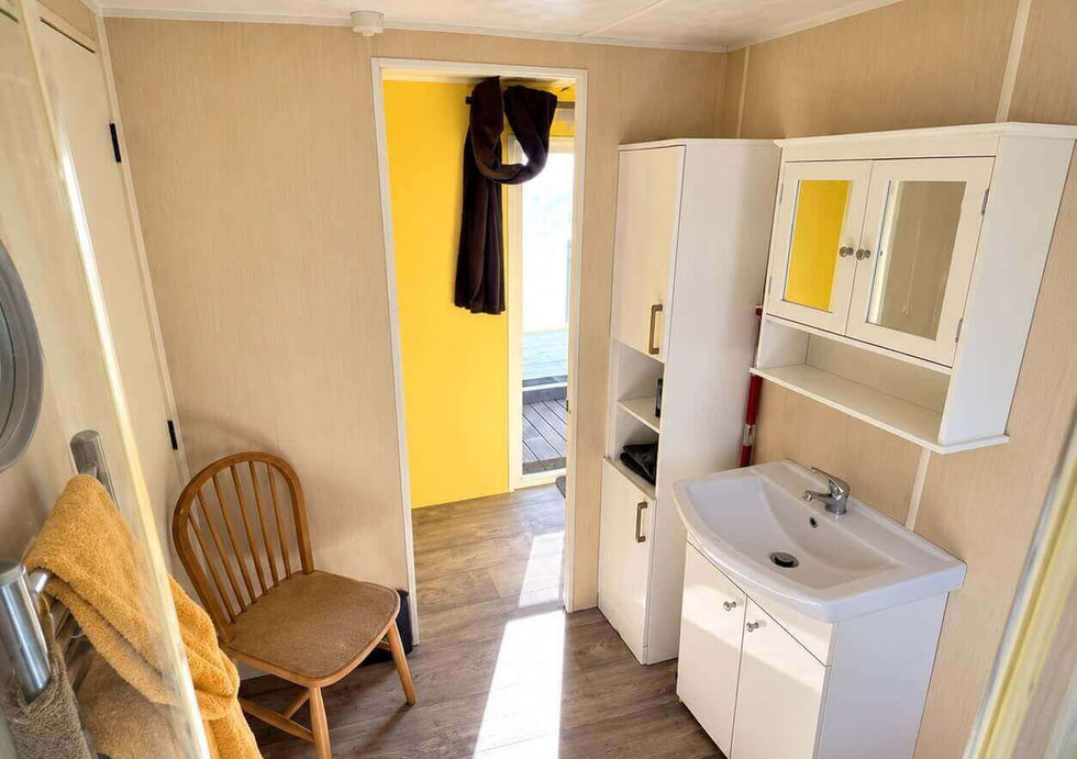 Bright shower room aboard Peggy Rose with basin, storage and large shower cubicle.