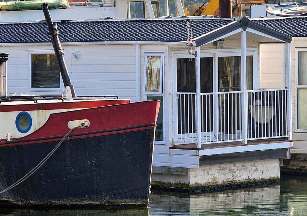 Houseboat exterior with covered deck and neighbouring Dutch barge.