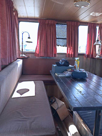 Interior view of a houseboat with table, seating, and windows. Premier Houseboats.