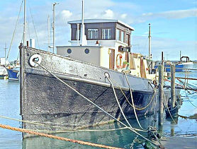 Sturdy dark boat with a cabin docked in the water