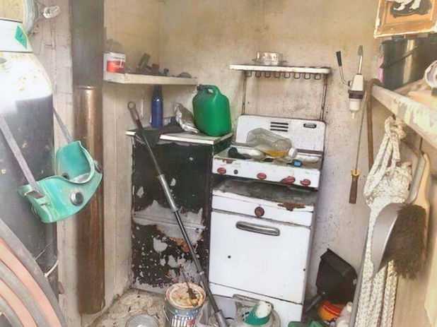 A kitchen with a stove and a broom