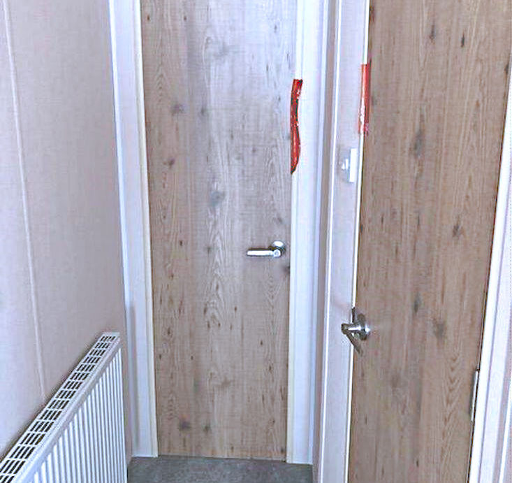  A hallway featuring two doors and a radiator.
